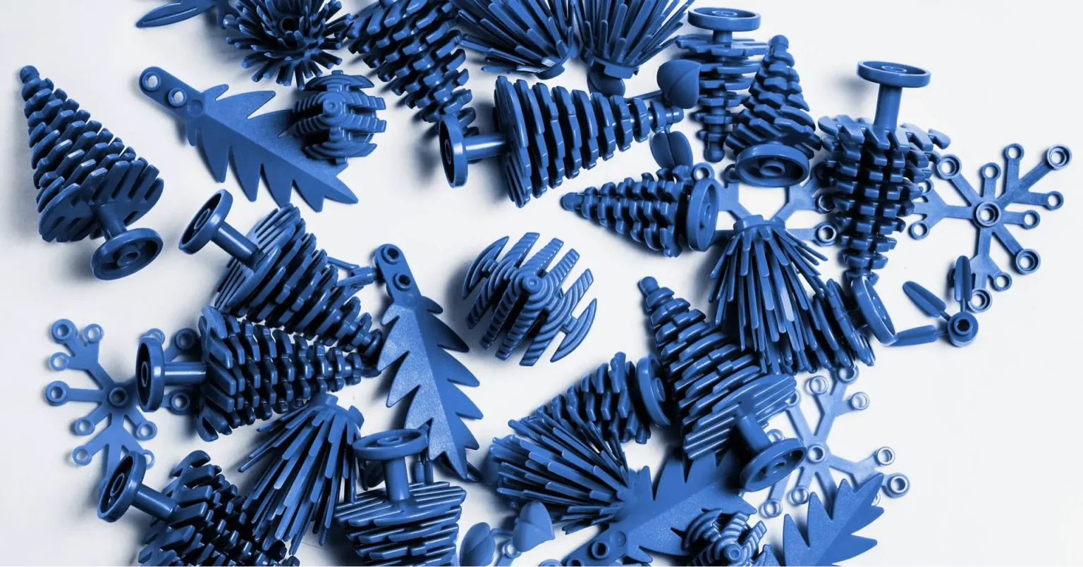 Blue plastic trees displayed on a white surface