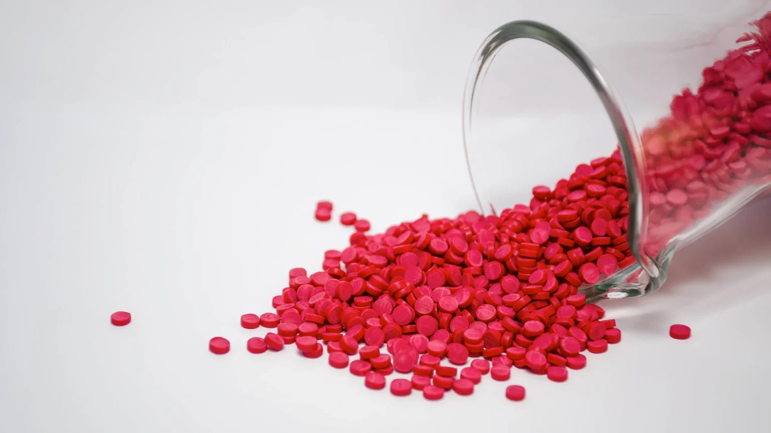 Red pills spread on a white surface